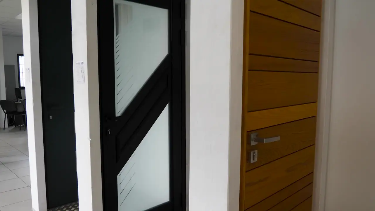 Porte d’entrée noire à vitrages en diagonale et porte d’entrée d’aspect bois à rainures