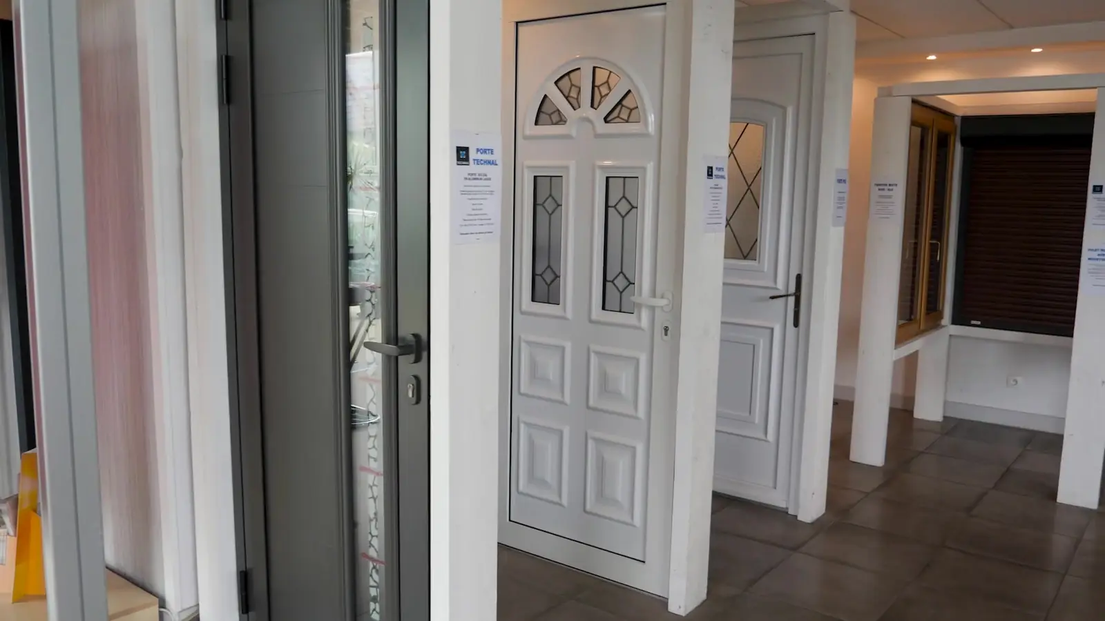 Portes d’entrée exposées : porte blanche à vitrages décorés en demi-lune, porte grise contemporaine