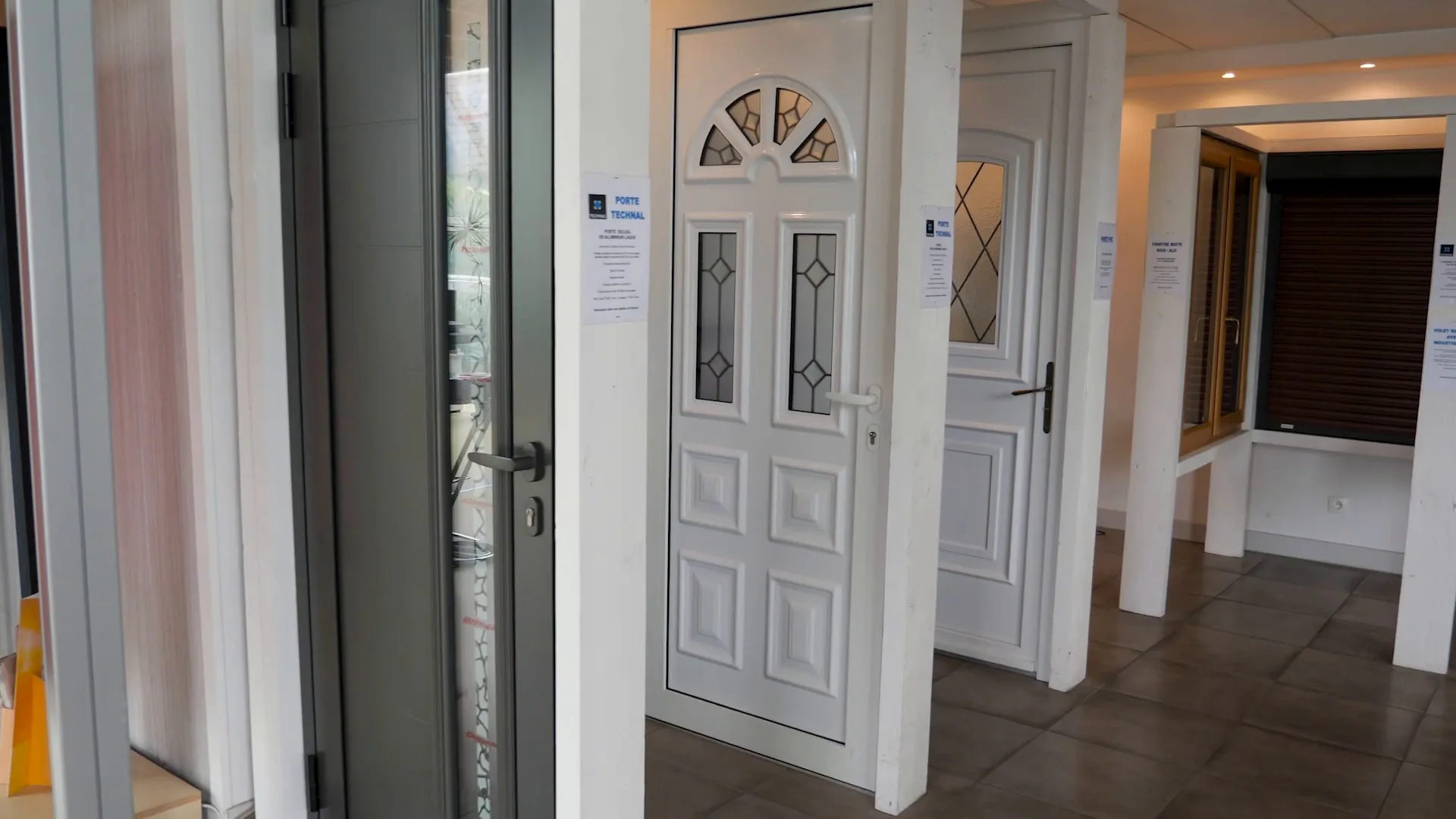 Portes d’entrée exposées : porte blanche à vitrages décorés en demi-lune, porte grise contemporaine