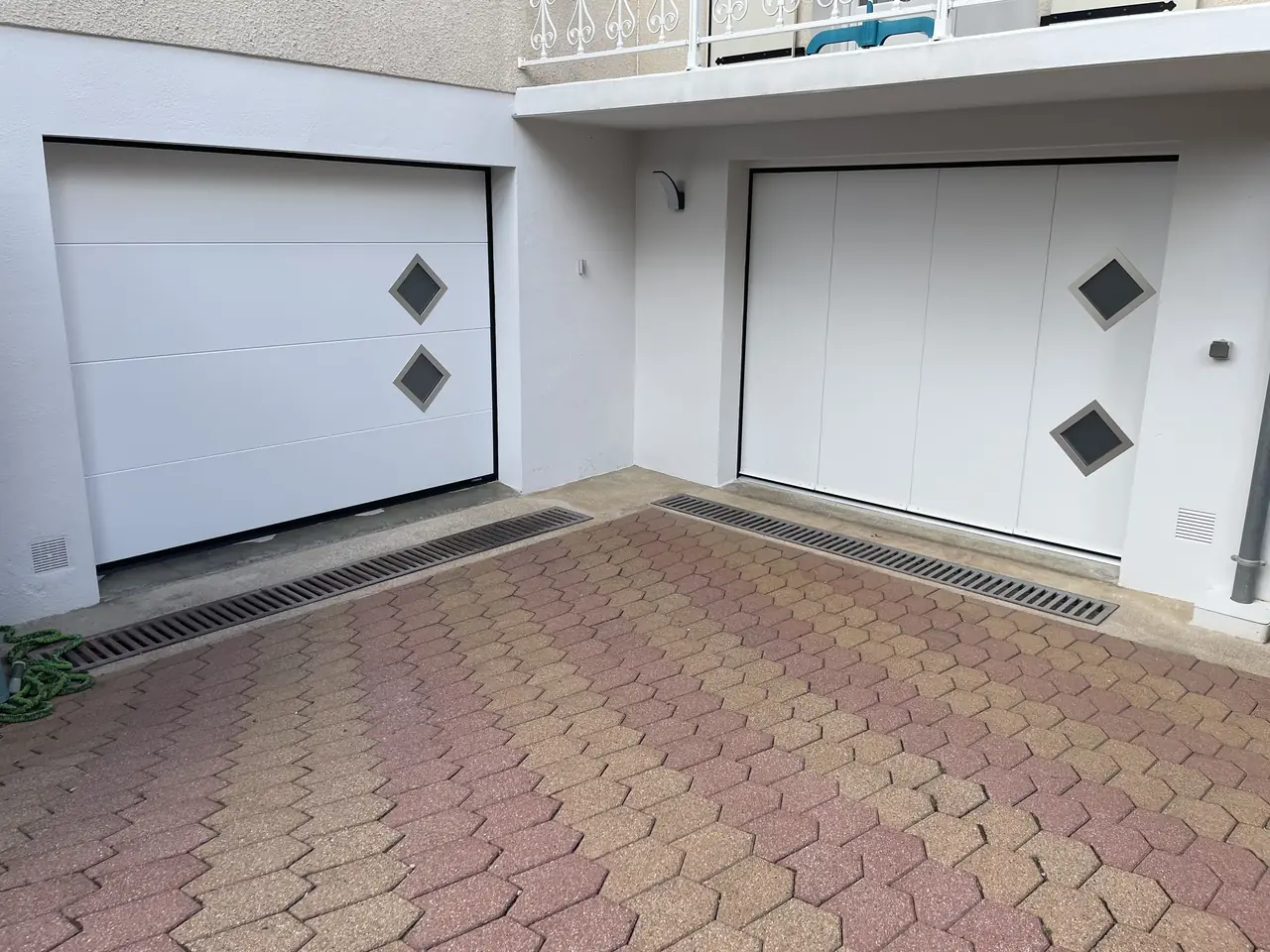 Deux portes de garage sectionnelles blanches avec hublots en losange